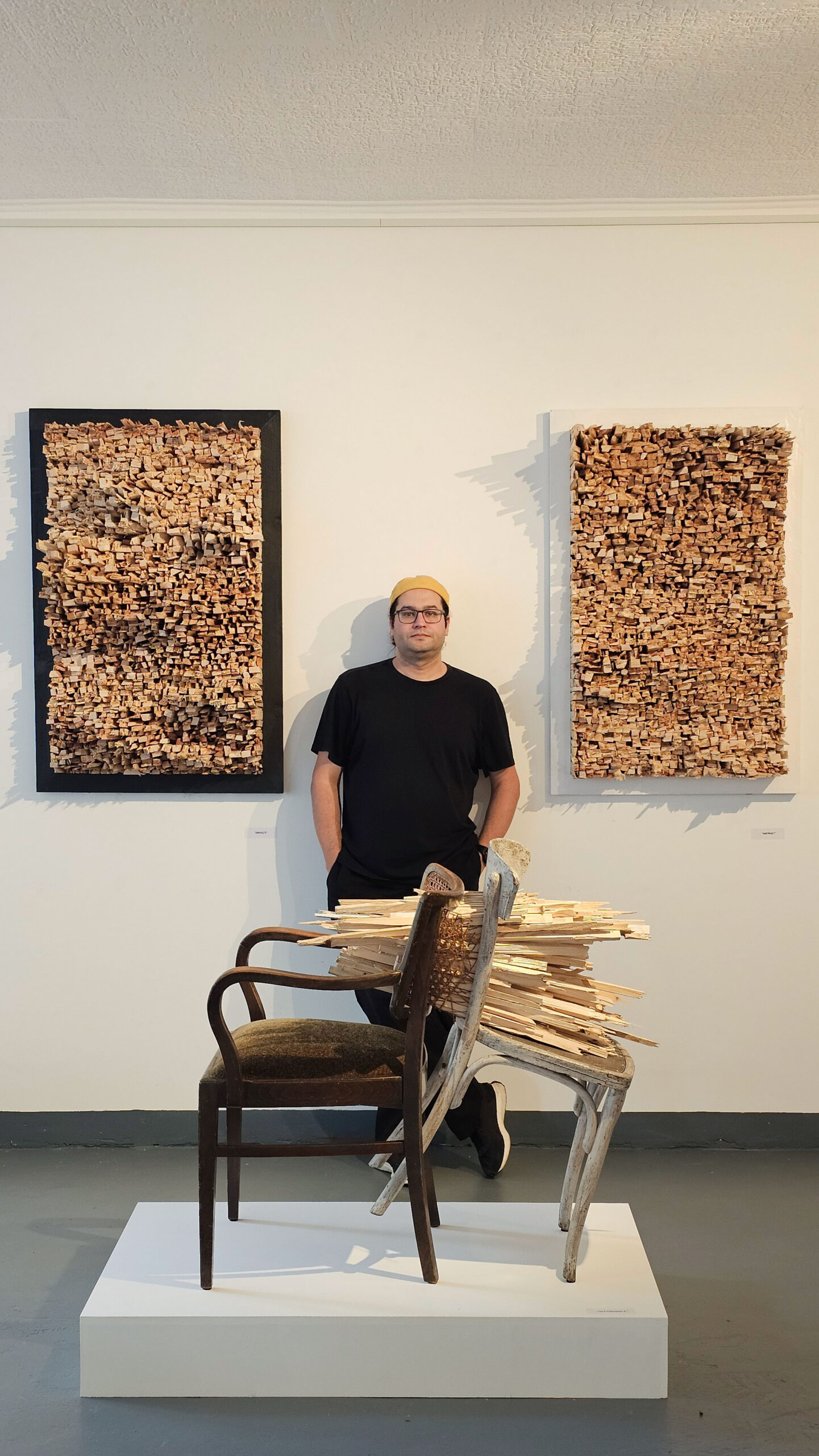 Ardalan Mirhadi mit seinen Werken in einer Ausstellung